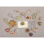 Twenty costume jewellery brooches including gilt and white paste set examples.