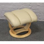 A cream leather stressless style foot stool.