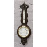 An early 20th century carved dark oak banjo barometer with porcelain dial.