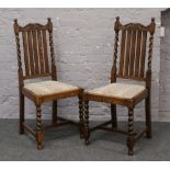 A pair of oak barley twist side chairs with scroll carved cresting rails.