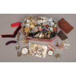 A tin of collectables  to include military badges, pocket watches, leather wallets etc.