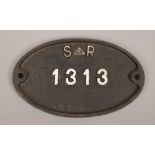 A vintage oval cast iron builders wall plaque reads S.E.R 1313.