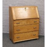 A light oak bureau with fitted interior.