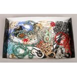A tray of costume jewellery beads and brooches.