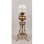 An ornate brass oil lamp base with clear and frosted glass shade, height without shade 62cm.