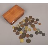 A wooden box of Georgian and Victorian coins and tokens to include bread tokens, pennies etc.