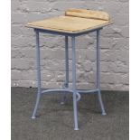 A child's desk with hardwood top on painted steel base.