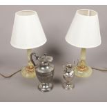 A pair of onyx and brass bedside table lamps along with two silver plate jugs.