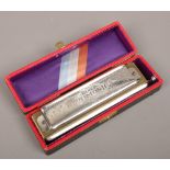 A vintage cased super chromonica mouth organ made in Germany by M. Hohner.
