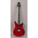 A Paul Reed Smith PRS SE electric guitar in orianthi red sparkle in makers red gig carry bag.