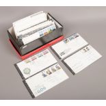 A box of British Post Office and Royal Mail first day covers.