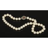 A pearl necklace with silver and coloured paste stone clasp.