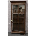 A George V tall oak bookcase with astrigal glazed door and raised on turned onion feet. (197cm x