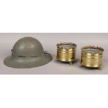 A 1941 World War II Tommy helmet, along with a pair of World War One trench art shell cases.