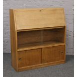 A light oak bureau with bookcase base.