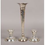 A pair of George V silver candlesticks, assayed Birmingham 1918, along with a silver tulip vase, all