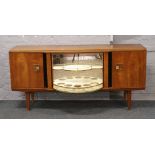 A retro teak breakfront cocktail sideboard with rotating display / cocktail cabinet.