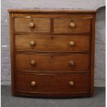A Victorian mahogany bow front chest of drawers with turned handles.