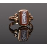 An early 20th century 9ct gold and carved hardstone cameo ring with split scroll shoulders. Size R.