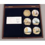 A cased set of HMS Victory gilt metal and enamel coins.