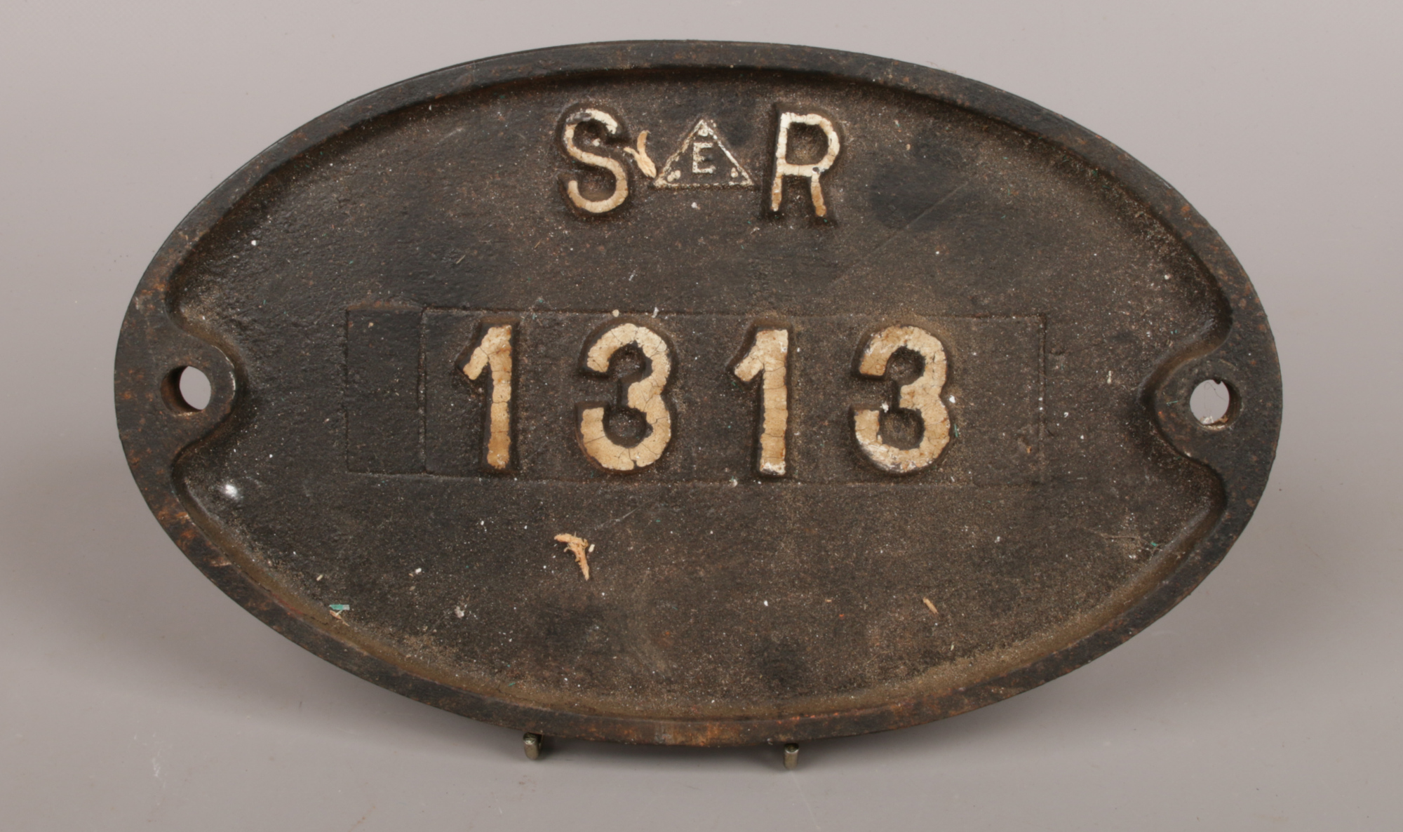 A vintage oval cast iron builders wall plaque reads S.E.R 1313.