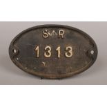 A vintage oval cast iron builders wall plaque reads S.E.R 1313.