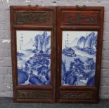 Two Chinese blue and white rectangular plaques in carved wooden frames with bronze hanging lamps,