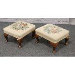 A pair of wool work top foot stools raised on squat cabriole legs.