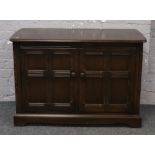 A dark oak Ercol hifi cabinet, W 107cm x D 31cm x H 49cm.