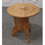 An Indian hardwood occasional  table with carved decoration and brass inlaid top.