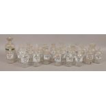 Approximately 25 glass chemist bottles and stoppers mostly with printed lettering.