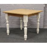 A part painted pine dining table with turned and reeded legs.