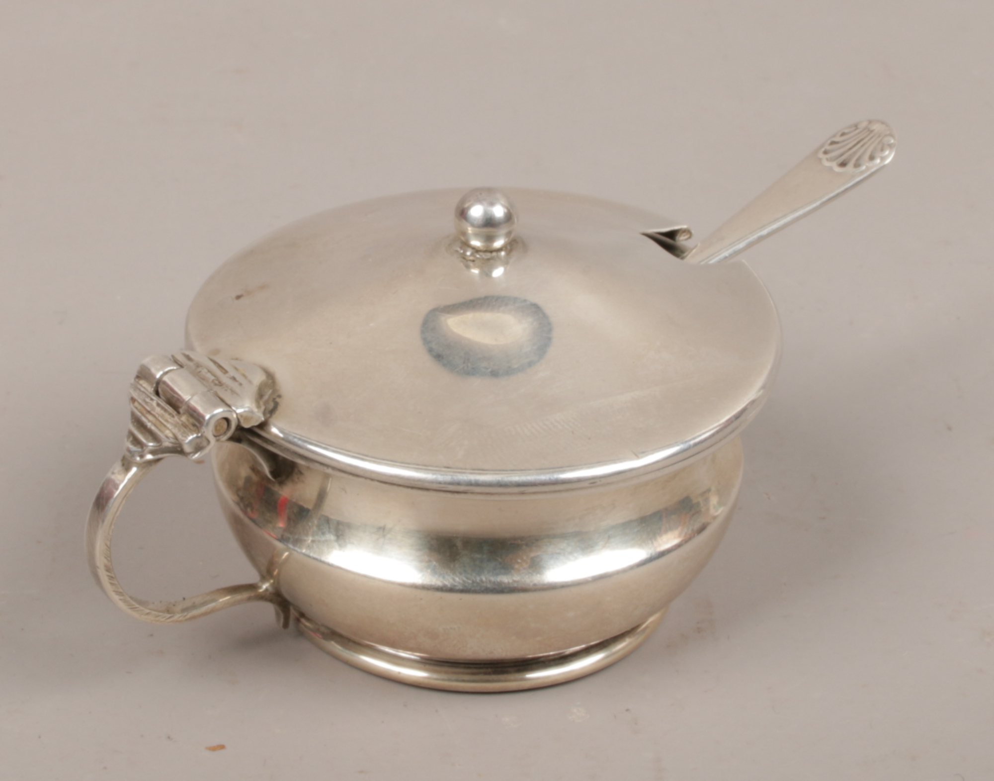 A silver mustard pot and silver spoon with Bristol blue liner, assayed Birmingham 1924 by Napper &