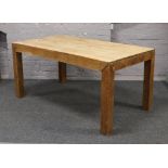 A hardwood dining table raised on square supports, L 106cm x D 90cm x H 76cm.