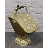 An early 19th century embossed brass pedestal coal scuttle and scoop.