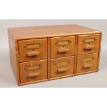 A small oak bank of six drawers, H 24cm x W 48cm x D 31cm.