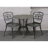 A cast aluminium garden table and two chairs.