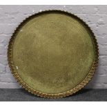 A large Islamic brass serving tray. With fluted rim and engraved with Quranic script, 72.5cm