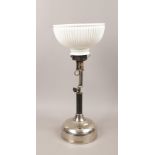 A paraffin lamp with chrome plated base and fluted opaque glass shade.