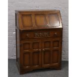 A carved oak and panelled fall front bureau over cupboard base by Jentique Furniture, H 108cm x W