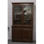 A 19th century mahogany bookcase on cupboard base with lion mask handles.