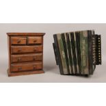 An oak apprentice chest of drawers and a Portland accordion.