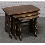 A nest of three Ercol dark oak occasional tables.