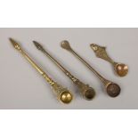 Four antique eastern bronze spoons one decorated with a fish terminal.