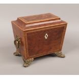 A twin handle Regency yew wood tea caddy with crossbanding and box wood strung inlay raised on brass