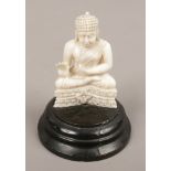 An early 20th century oriental carved ivory figure of a seated Buddha on ebonised plinth.