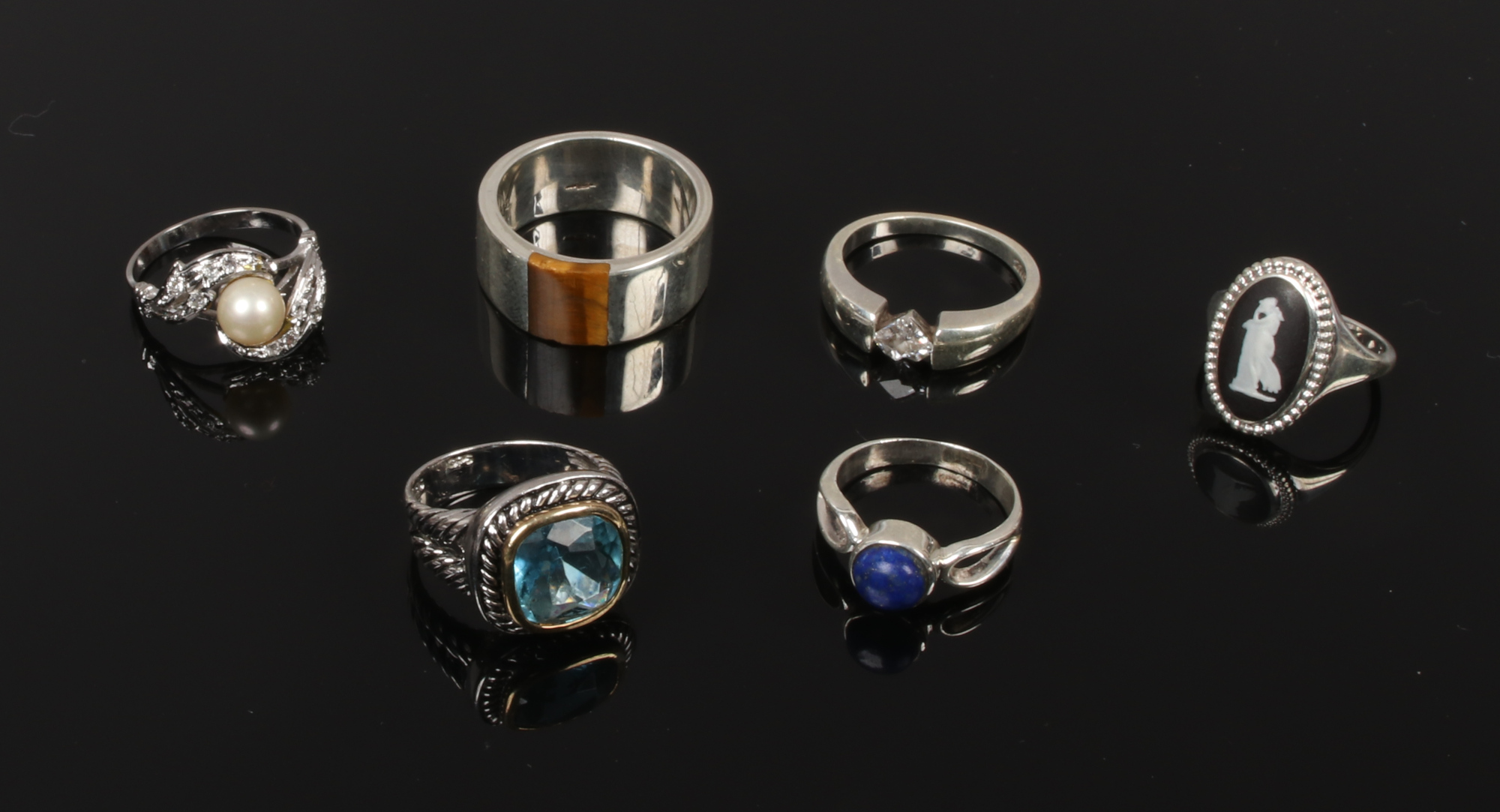 Six silver dress rings including black Jasperware, tigers eye and Lapis Lazuli.