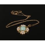 A 9ct gold pendant and chain set with jadeite cabochon centre stone surrounded by seed pearls and