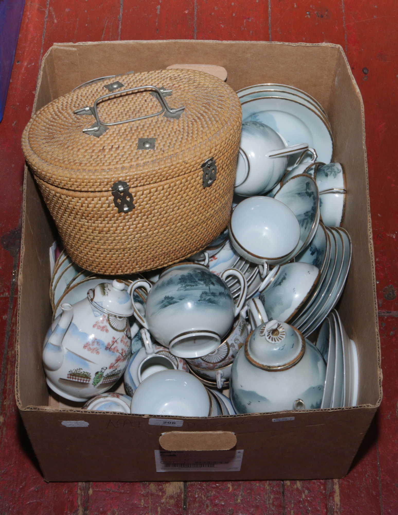 Two Chinese part tea sets decorated with oriental views, along with tea pot and tea bowls in a lined