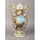 A Coalbrookdale china style urn decorated with a cottage view and applied flowers marked J.P to